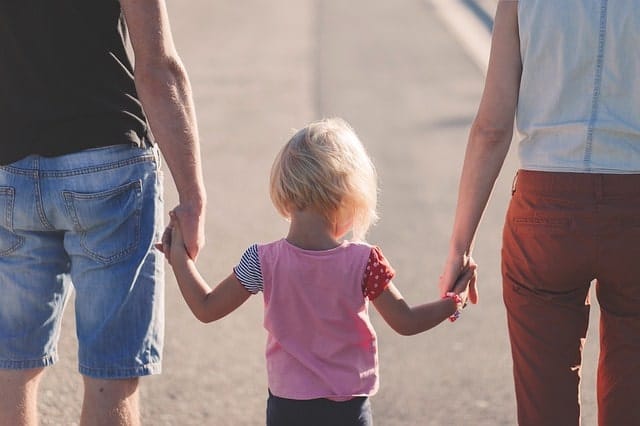 Mom and Dad holding daughter's hands