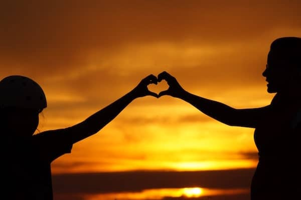 Parent and child holding hands to make a heart 