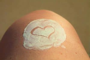 Sunscreen with heart drawn on the skin