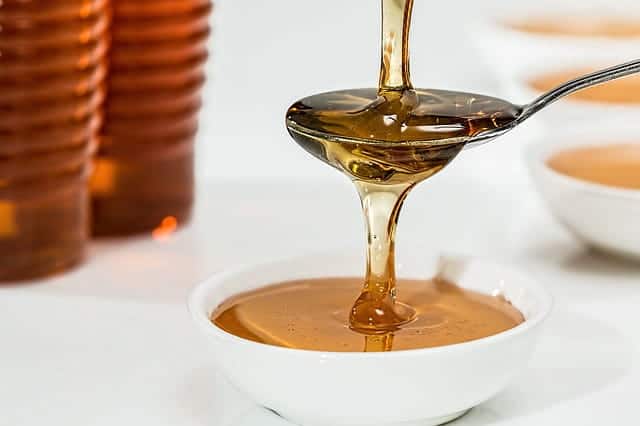 Organic honey pouring onto a spoon