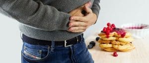 Man holding stomach in pain after eating gluten