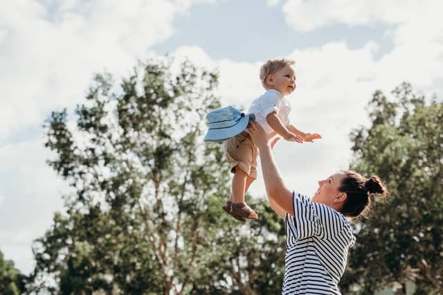 Mother throwing toddler son up in the air