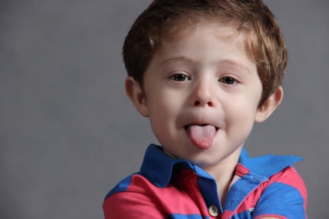 toddler boy sticking out his tongue