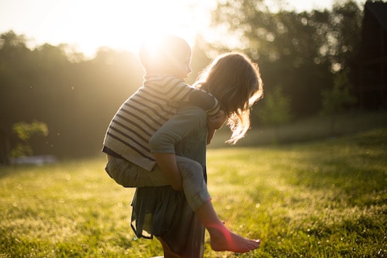 Mom giving son a piggyback ride