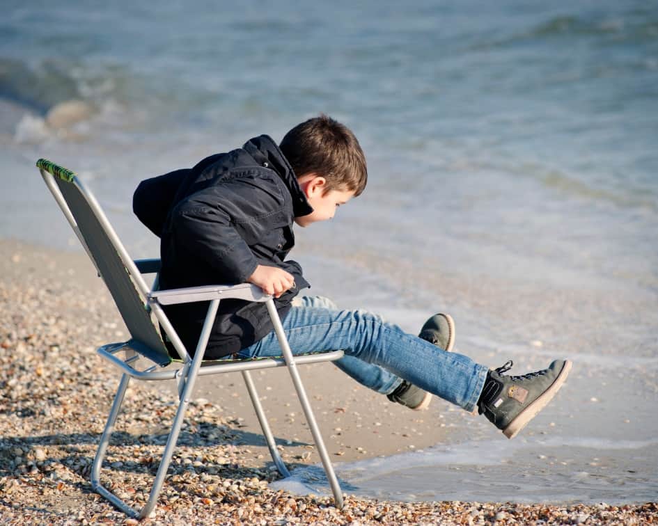 Boy lifting legs on seashore