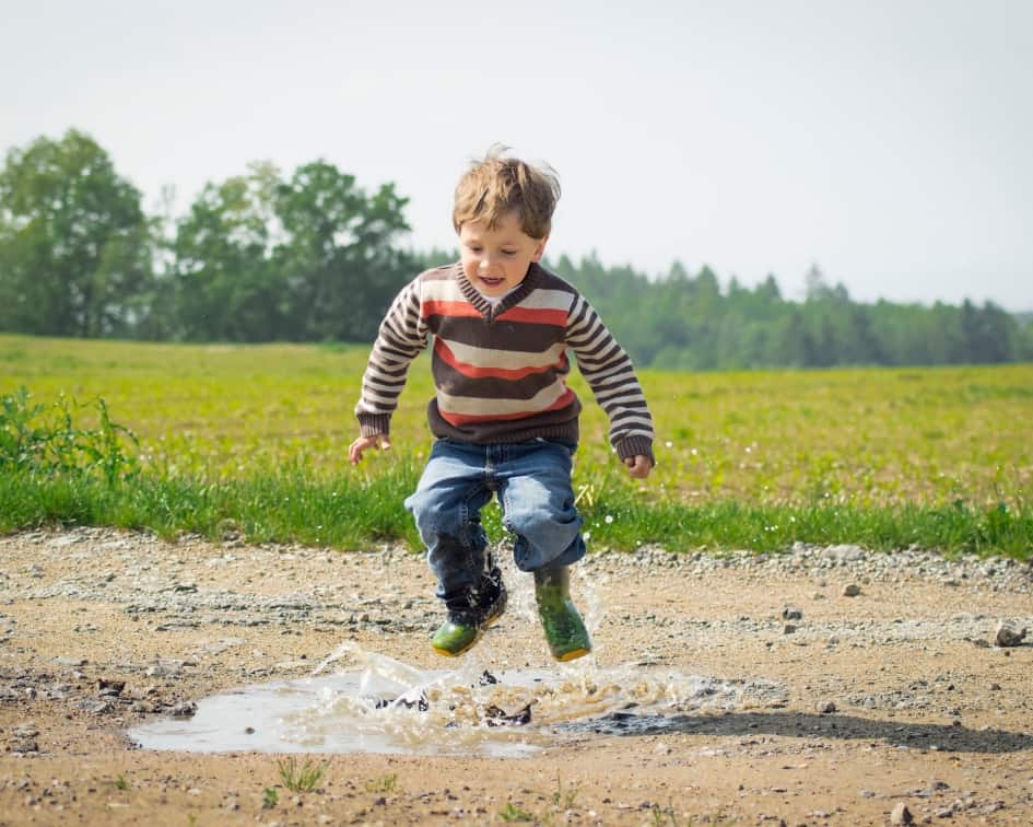 Boy splashing in puddle