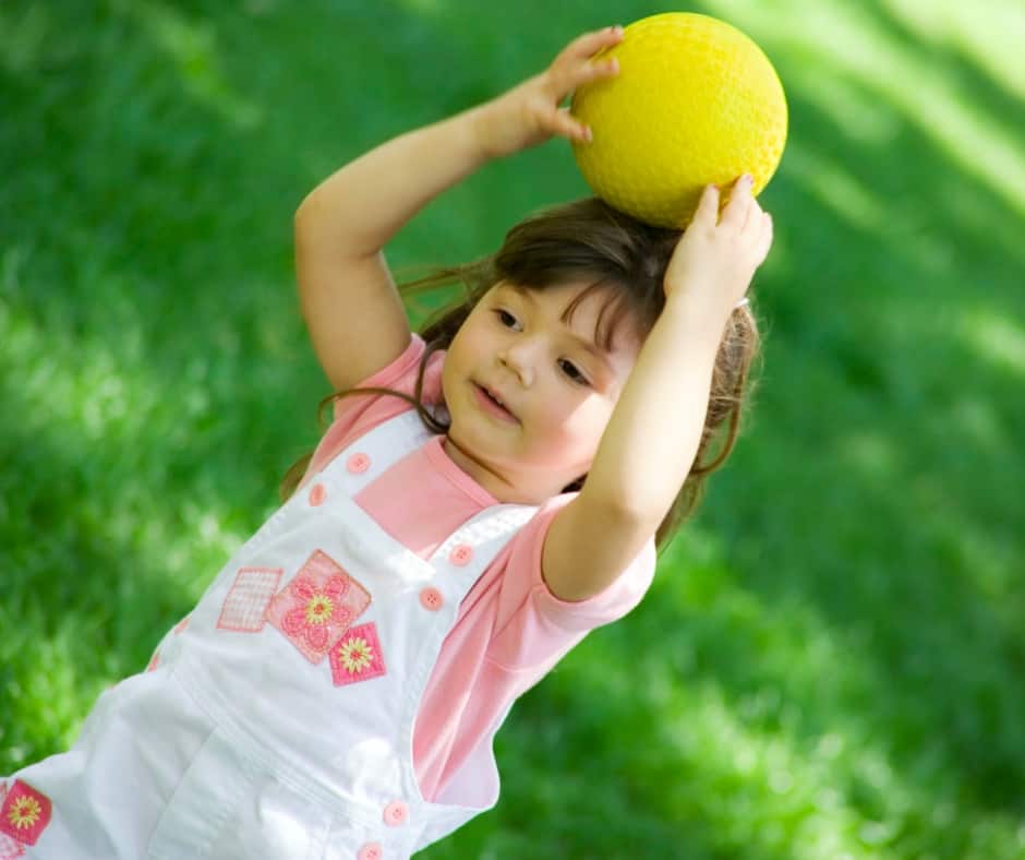 Little girl with a yellow ball on her head
