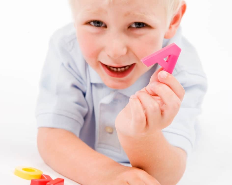 Child holding an A toy