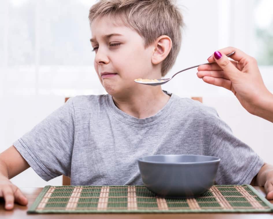 Boy refusing food on a spoon